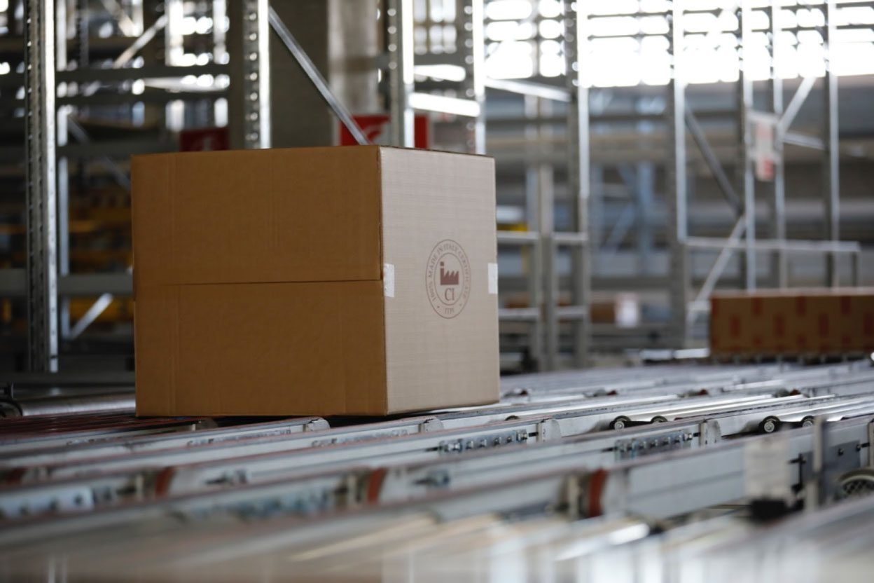 Cabinetry packaging and delivery process with boxed products on conveyor system ready for installation