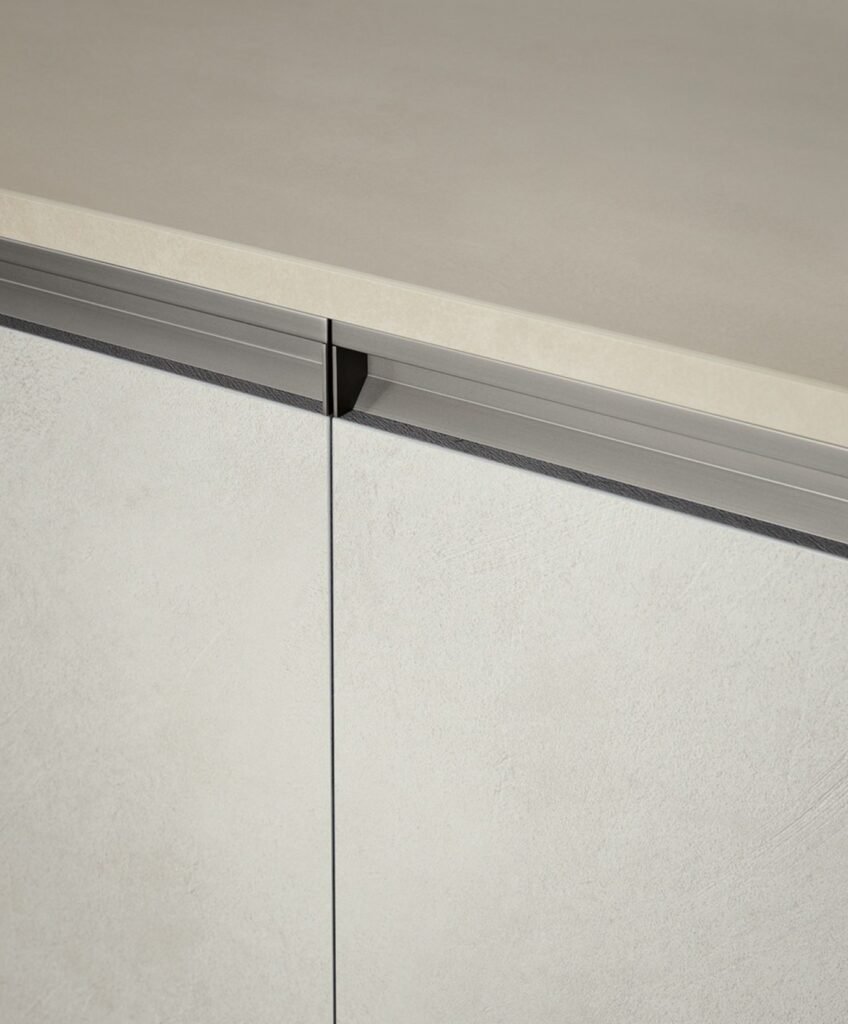 Close-up of a decorative melamine cabinet door with a light textured finish and slim integrated handle rail for a modern European kitchen design.