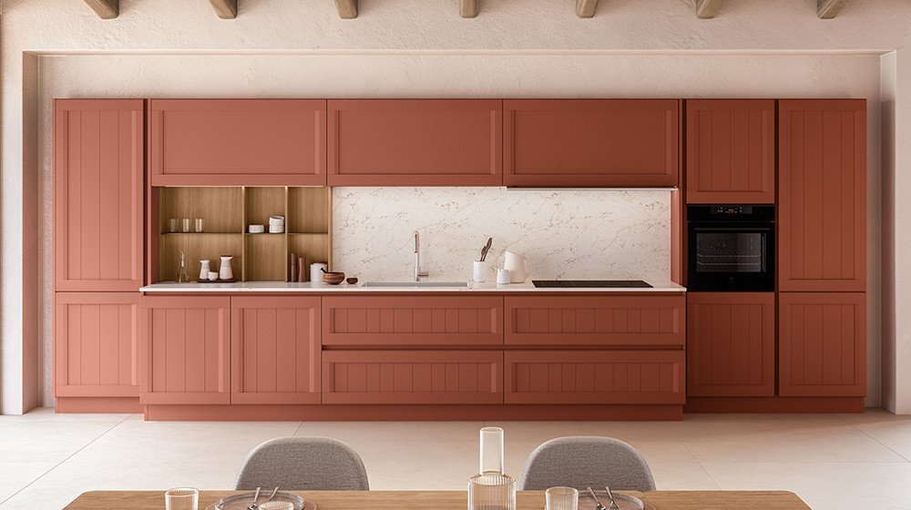 Discover the Armonia collection by Veneta Cucine at Studio Quattro Design. This unique layout beautifully balances traditional slatted-panel door textures with a rich, modern terracotta finish and a fine marble backsplash.