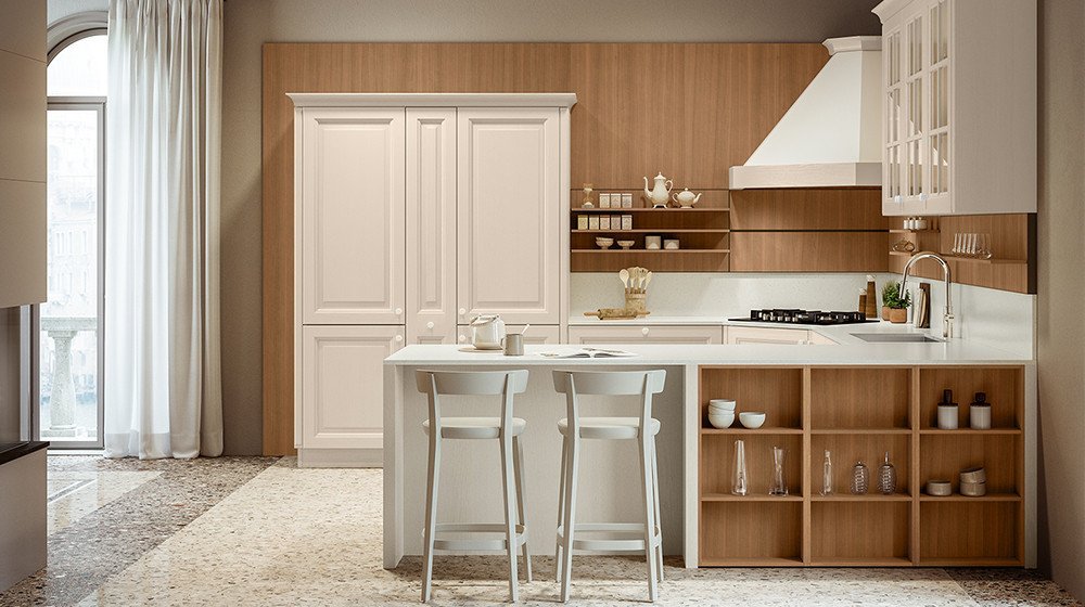 Explore the Pavese collection by Veneta Cucine at Studio Quattro Design. This timeless transitional layout elegantly features classic cream raised-panel cabinetry, a traditional plastered hood finish, and custom warm wood accent shelving.