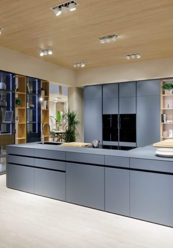 Contemporary kitchen with Italian cabinetry, wood ceiling detail, and integrated storage solutions in a modern home