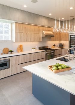 Modern kitchen cabinet design with long island, natural wood cabinets, integrated appliances, and sleek contemporary finishes.