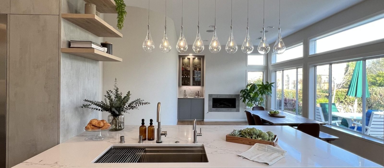 Kitchen and bath showrooms near me featuring luxury open concept kitchen design with waterfall island, modern cabinetry, pendant lighting, and premium finishes.