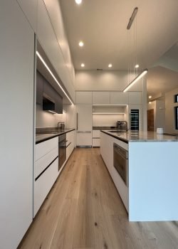 Modern kitchen cabinet design with minimalist white cabinetry, recessed lighting, and sleek modern finishes.