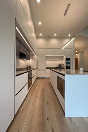 Modern kitchen cabinet design with minimalist white cabinetry, recessed lighting, and sleek modern finishes.