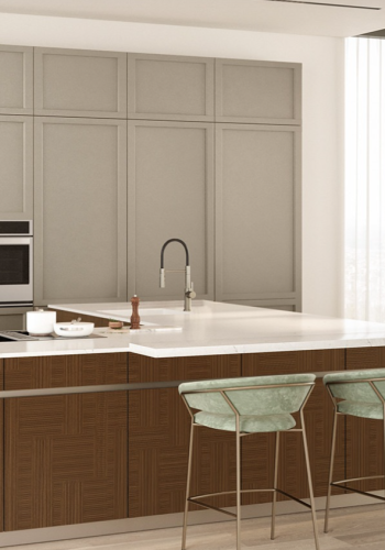 Classic neutral kitchen with paneled upper cabinetry, natural wood island cabinets, integrated appliances, white countertop, and elegant bar seating.
