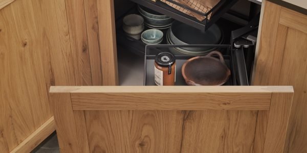 Natural wood kitchen cabinet with pull-out corner storage, organized dishes, cookware, and pantry items inside a modern Italian cabinetry system.