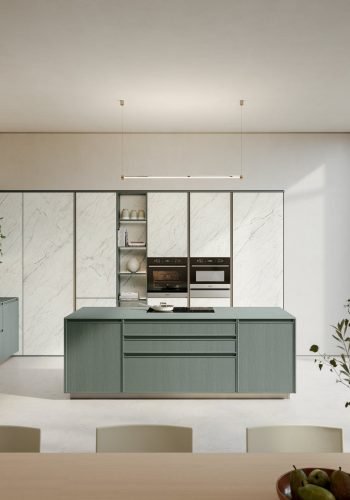 Timeless Italian kitchen with soft green island cabinetry, marble cabinet fronts, open shelving, integrated ovens, and large glass doors to the garden